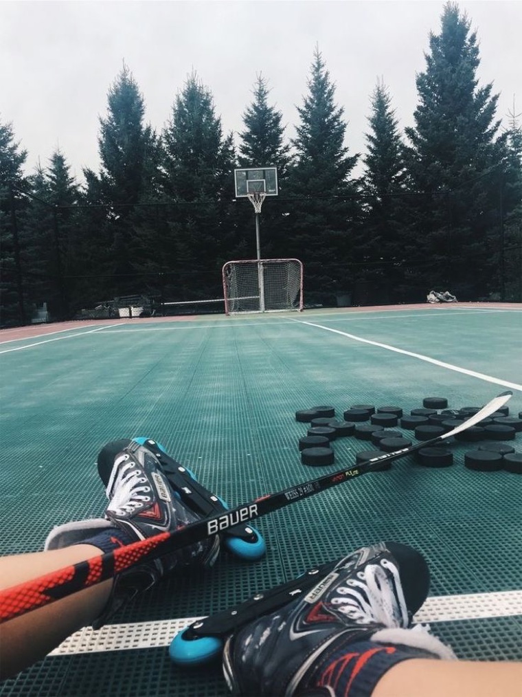 Joueur de hockey roller, bâton et balle sur la surface